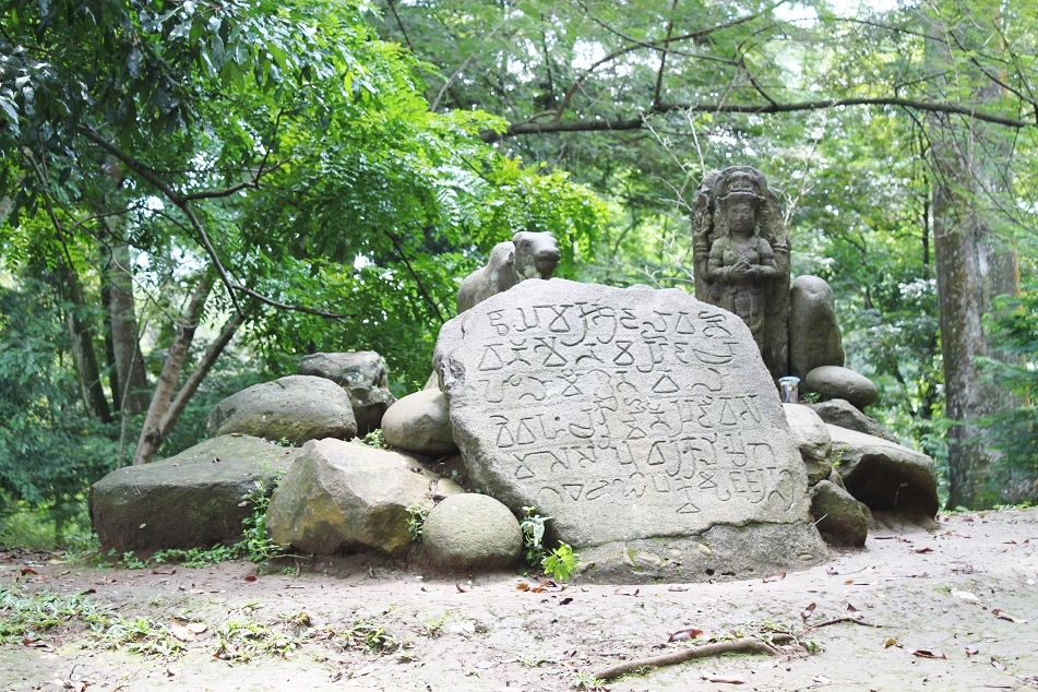 An Ancient Hindu Statue next to A 19th-Century Inscription